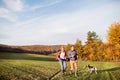 Senior couple with dog on a walk in an autumn nature. Royalty Free Stock Photo