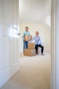 Senior Couple Downsizing In Retirement Carrying Boxes Into New Home On Moving Day Royalty Free Stock Photo