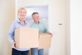 Senior Couple Downsizing In Retirement Carrying Boxes Into New Home On Moving Day Royalty Free Stock Photo