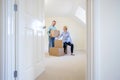 Senior Couple Downsizing In Retirement Carrying Boxes Into New Home On Moving Day