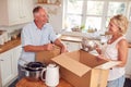 Senior Couple Downsizing In Retirement Packing And Labelling Boxes Ready For Move Into New Home