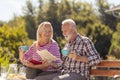 Senior couple drinking coffee and reading in the backyard Royalty Free Stock Photo