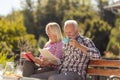 Senior couple drinking morning coffee and reading in the backyard Royalty Free Stock Photo