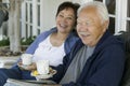 Senior couple drinking tea on porch smiling