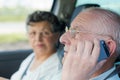 Senior couple driving car while using phone Royalty Free Stock Photo
