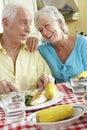 Senior Couple Eating Meal Together In Kitchen Royalty Free Stock Photo