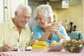 Senior Couple Eating Meal Together In Kitchen Royalty Free Stock Photo