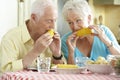 Senior Couple Eating Meal Together In Kitchen Royalty Free Stock Photo