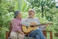 senior couple elderly man playing the guitar while his wife is singing together Royalty Free Stock Photo