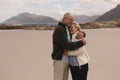 Senior couple embracing standing at the beach Royalty Free Stock Photo