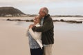 Senior couple embracing standing at the beach Royalty Free Stock Photo