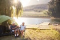 Senior Couple Enjoying Camping Vacation By Lake Making A Toast Royalty Free Stock Photo