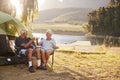 Senior Couple Enjoying Camping Vacation By Lake Making A Toast Royalty Free Stock Photo