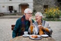 Senior couple enjoying cup of coffee and cake outdoor in cafe. Royalty Free Stock Photo