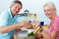 Senior Couple Enjoying Meal In Seafront Restaurant