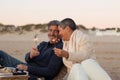 Senior couple enjoying picnic at seashore, holding sparklers Royalty Free Stock Photo