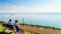 Senior couple enjoying a rest and view of the inland sea named IJselmeer with its wind farms