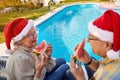 Senior couple enjoying in watermelon and celebrating  Christmas time Royalty Free Stock Photo