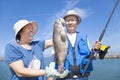 Senior couple fishing and showing big grouper