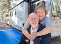 Senior Couple In Front of Their Beautiful RV At Campground.