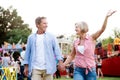 Senior couple at the fun fair, holding hands, walking. Royalty Free Stock Photo