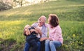Senior couple with granddaughter outside in spring nature, relaxing on the grass. Royalty Free Stock Photo