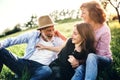 Senior couple with granddaughter outside in spring nature, relaxing on the grass. Royalty Free Stock Photo