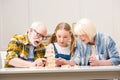 Senior couple with granddaughter playing jenga game at home