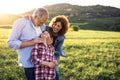 Senior couple with granddaughter standing outside in spring nature. Copy space. Royalty Free Stock Photo