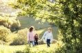 Senior couple with granddaughter on a walk outside in spring nature. Royalty Free Stock Photo