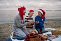 Senior couple with granddaugter celebrate New Year or Christmas and have picnic on beach. Royalty Free Stock Photo