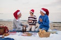 Senior couple with granddaugter celebrate New Year or Christmas and have picnic on beach. Royalty Free Stock Photo