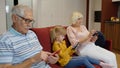 Senior couple grandparents with child girl granddaughter using digital tablet, mobile phone Royalty Free Stock Photo