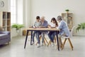 Senior couple grandparents spending time with grandchildren at home drawing at table. Royalty Free Stock Photo