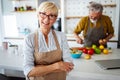 Senior couple having fun, cooking together in home kitchen Royalty Free Stock Photo