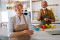 Senior couple having fun, cooking together in home kitchen Royalty Free Stock Photo