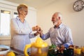 Senior couple having fun preparing healthy food on breakfast in the kitchen Royalty Free Stock Photo