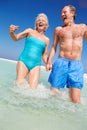 Senior Couple Having Fun In Sea On Beach Holiday Royalty Free Stock Photo