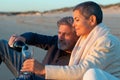Senior couple having picnic at seashore at sunset Royalty Free Stock Photo