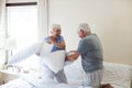 Senior couple having pillow fight on bed Royalty Free Stock Photo