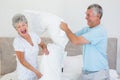 Senior couple having pillow fight in bed Royalty Free Stock Photo