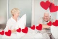 Senior couple having pillow fight in bedroom at home Royalty Free Stock Photo