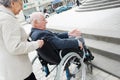 Senior couple having trouble moving disabled husband through city