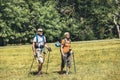 Couple hiking in forest wearing backpacks and hiking poles. Nordic walking, trekking. Healthy lifestyle Royalty Free Stock Photo