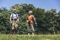 Senior couple hiking in forest wearing backpacks and hiking poles. Nordic walking, trekking. Royalty Free Stock Photo