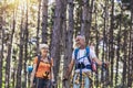 Couple hiking in forest wearing backpacks and hiking poles. Nordic walking, trekking. Healthy lifestyle Royalty Free Stock Photo