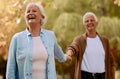 Senior couple, holding hands and happy smile together in park, romance and love outdoor in park on date. Elderly man Royalty Free Stock Photo