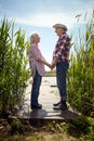 Senior couple holding hands, looking each other, smiling,  standing on  platform by the river Royalty Free Stock Photo