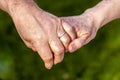 Senior couple holding hands while sitting together in the garden Royalty Free Stock Photo