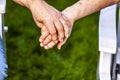 Senior couple holding hands while sitting together in the garden Royalty Free Stock Photo